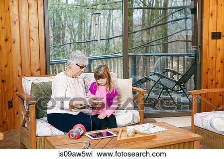 Senior woman teaching granddaughter how to knit on living room sofa View Large Photo Image Stock Image - Senior woman teaching granddaughter how to knit on living room sofa. Fotosearch