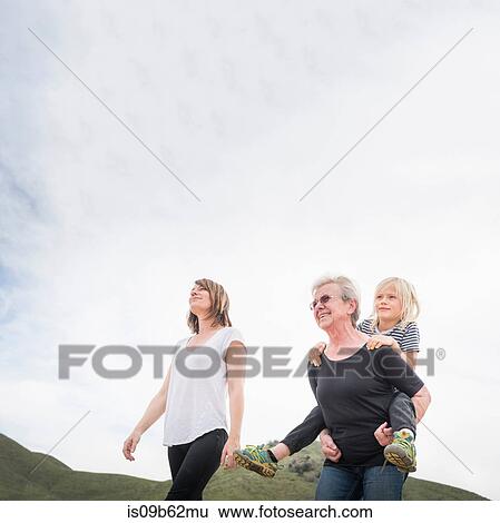 Stock Photograph - Senior woman walking with daughter and grandson. Fotosearch
