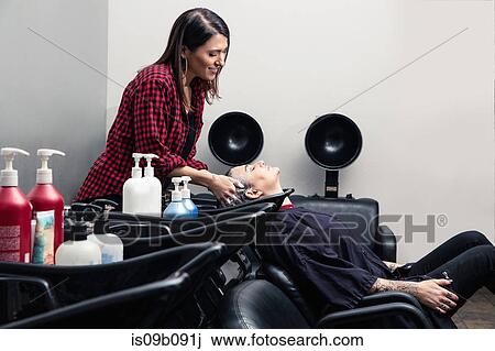 Shampoo girl rinsing customer's hair in salon View Large Photo Image Stock Image - Shampoo girl rinsing customer's hair in salon. Fotosearch