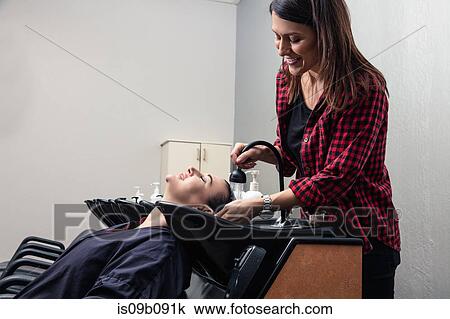Shampoo girl rinsing customer's hair in salon View Large Photo Image Stock Image - Shampoo girl rinsing customer's hair in salon. Fotosearch