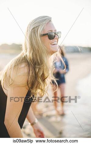 Side view of blonde woman on beach wearing sunglasses looking away smiling View Large Photo Image Stock Photography - Side view of blonde woman on beach wearing sunglasses looking away smiling. Fotosearch