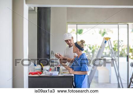 Side view of couple standing at kitchen counter covered in decorating equipment View Large Photo Image Stock Image - Side view of couple standing at kitchen counter covered in decorating equipment. Fotosearch