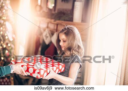 Side view of girl receiving gift at christmas looking down smiling View Large Photo Image Stock Photo - Side view of girl receiving gift at christmas looking down smiling. Fotosearch