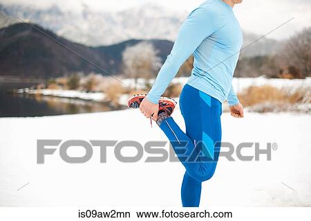 Side view of male runner warming up by snow covered lakeside, Lake Kawaguchiko, Mount Fuji, Japan View Large Photo Image Picture - Side view of male runner warming up by snow covered lakeside, Lake Kawaguchiko, Mount Fuji, Japan. Fotosearch