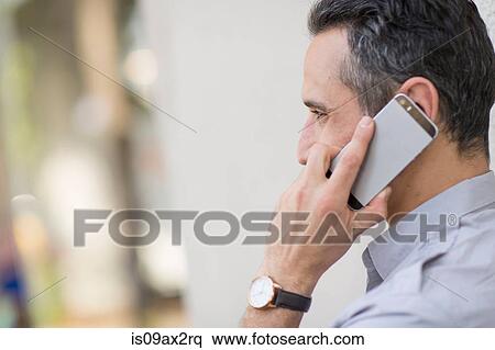 Side view of man using smartphone to make telephone call View Large Photo Image Stock Photography - Side view of man using smartphone to make telephone call. Fotosearch
