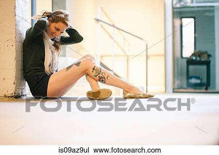 Side view of tattooed woman sitting against wall View Large Photo Image Stock Image - Side view of tattooed woman sitting against wall. Fotosearch