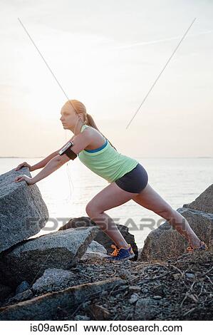 Side view of woman wearing activity tracker stretching on rocks View Large Photo Image Stock Image - Side view of woman wearing activity tracker stretching on rocks. Fotosearch