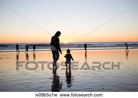 Stock Photo - Silhouette of mother and baby boy on beach at sunset, Venice Beach, Los Angeles, California, USA. Fotosearch