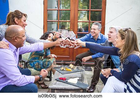 Six mature adults friends making wine toast at garden party on patio View Large Photo Image Stock Image - Six mature adults friends making wine toast at garden party on patio. Fotosearch