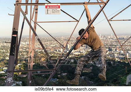 Soldier wearing combat clothing dangling from electricity pylon, Runyon Canyon, Los Angeles, California, USA View Large Photo Image Picture - Soldier wearing combat clothing dangling from electricity pylon, Runyon Canyon, Los Angeles, California, USA. Fotosearch