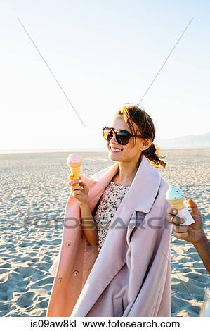 Stylish young woman with boyfriend eating ice cream cone strolling on beach, Venice Beach, California, USA View Large Photo Image Stock Image - Stylish young woman with boyfriend eating ice cream cone strolling on beach, Venice Beach, California, USA. Fotosearch