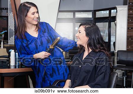 Stylist attending to customer in hair salon View Large Photo Image Stock Photo - Stylist attending to customer in hair salon. Fotosearch