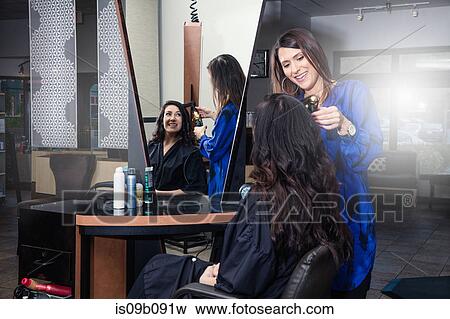 Stylist attending to customer in hair salon View Large Photo Image Stock Photo - Stylist attending to customer in hair salon. Fotosearch
