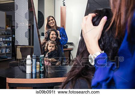 Stylist attending to customer in hair salon View Large Photo Image Stock Photograph - Stylist attending to customer in hair salon. Fotosearch