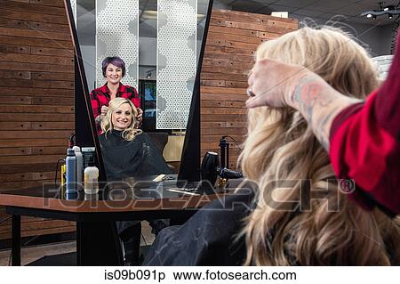 Stock Photography - Stylist attending to customer in hair salon. Fotosearch