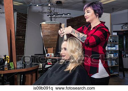 Stylist attending to customer in hair salon View Large Photo Image Stock Photography - Stylist attending to customer in hair salon. Fotosearch