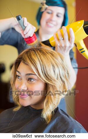 Stylist drying woman's hair in hair salon View Large Photo Image Stock Photograph - Stylist drying woman's hair in hair salon. Fotosearch