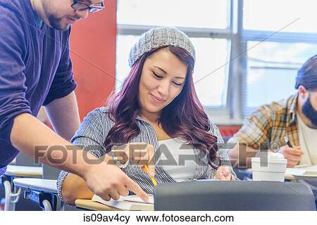 Teacher working with female college student at desk View Large Photo Image Stock Photo - Teacher working with female college student at desk. Fotosearch