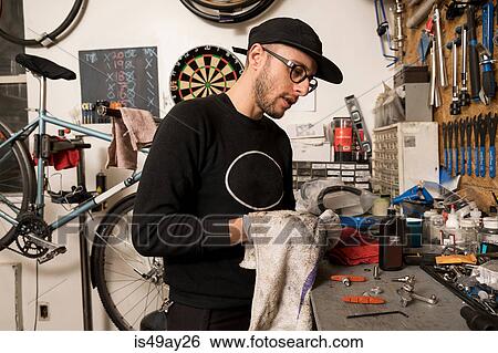 Stock Photograph - Technician in bicycle workshop. Fotosearch