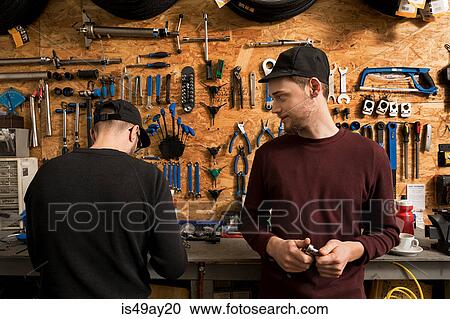 Stock Image - Technicians in bicycle workshop. Fotosearch