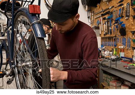 Stock Photography - Technicians in bicycle workshop. Fotosearch