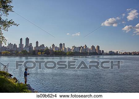 Teenage boy fishing from riverbank, New York, USA View Large Photo Image Picture - Teenage boy fishing from riverbank, New York, USA. Fotosearch