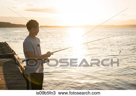 Stock Image - Teenage boy fishing, Pacific Rim National Park, Vancouver Island, Canada. Fotosearch