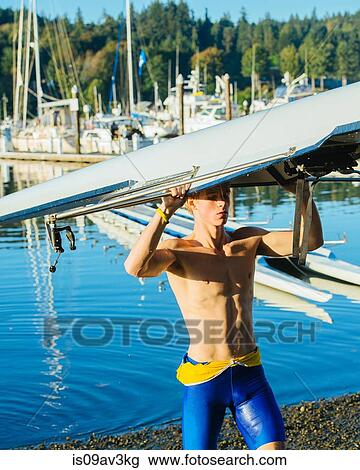 Teenage boy holding sculling boat above head View Large Photo Image Stock Image - Teenage boy holding sculling boat above head. Fotosearch