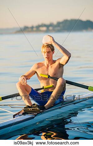Teenage boy in sculling boat, pouring water over head to cool him down View Large Photo Image Stock Image - Teenage boy in sculling boat, pouring water over head to cool him down. Fotosearch