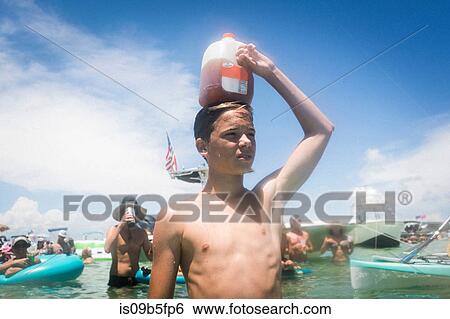 Teenage boy in water holding juice carton on head, Crab Island, Emerald Coast, Gulf of Mexico, USA View Large Photo Image Stock Photograph - Teenage boy in water holding juice carton on head, Crab Island, Emerald Coast, Gulf of Mexico, USA. Fotosearch