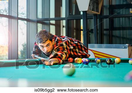 Teenage boy playing pool billiards View Large Photo Image Stock Image - Teenage boy playing pool billiards. Fotosearch
