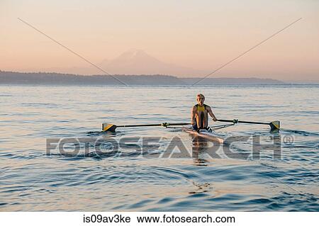Teenage boy sculling at dusk View Large Photo Image Stock Image - Teenage boy sculling at dusk. Fotosearch