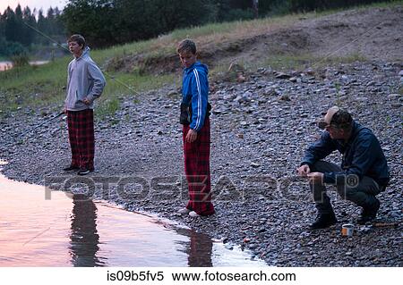 Stock Photography - Teenage boys and father by water's edge, Washington, USA. Fotosearch