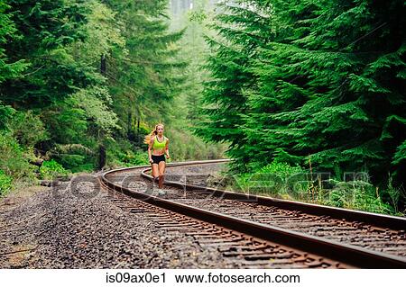 Teenage girl running along rural train track View Large Photo Image Stock Image - Teenage girl running along rural train track. Fotosearch