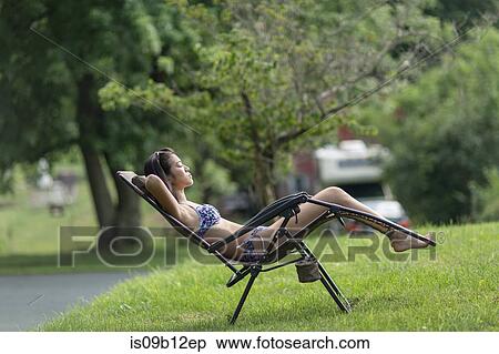 Teenage girl sunbathing on sun lounger in garden View Large Photo Image Stock Photography - Teenage girl sunbathing on sun lounger in garden. Fotosearch