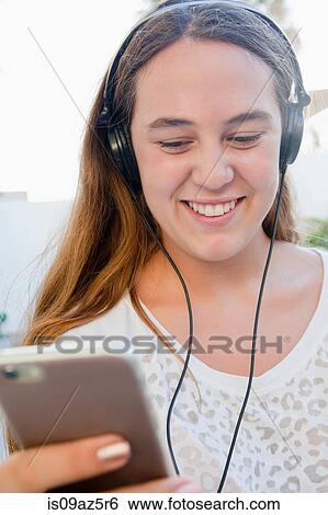 Teenage girl wearing headphones smiling View Large Photo Image Stock Photograph - Teenage girl wearing headphones smiling. Fotosearch