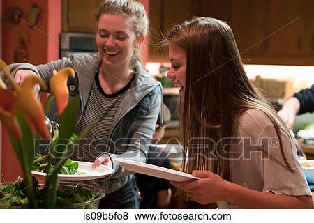Teenage girls in kitchen preparing meal View Large Photo Image Stock Photo - Teenage girls in kitchen preparing meal. Fotosearch