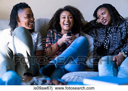 Three female friends, sitting on sofa, relaxing View Large Photo Image Stock Image - Three female friends, sitting on sofa, relaxing. Fotosearch