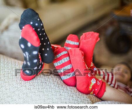 Three young siblings relaxing on sofa, feet raised, focus on feet View Large Photo Image Stock Image - Three young siblings relaxing on sofa, feet raised, focus on feet. Fotosearch
