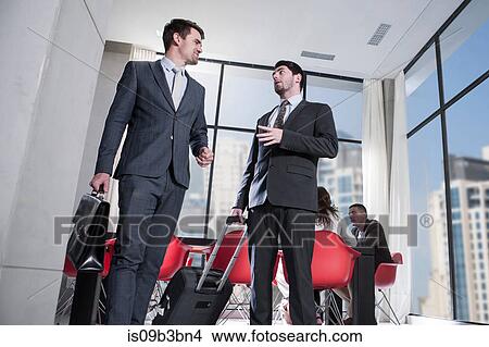 Two businessmen arriving in hotel lobby View Large Photo Image Picture - Two businessmen arriving in hotel lobby. Fotosearch