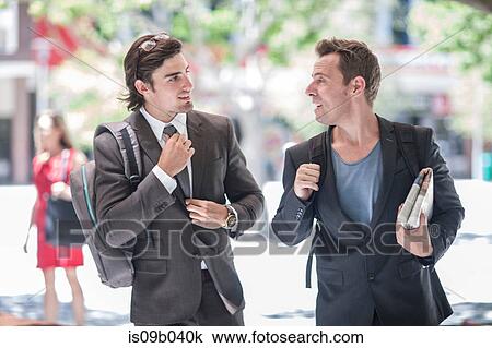 Two businessmen walking and talking in city View Large Photo Image Stock Image - Two businessmen walking and talking in city. Fotosearch