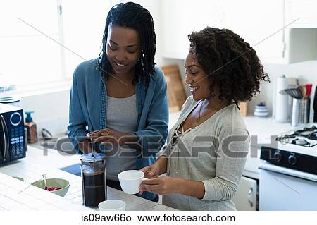 Picture - Two female friends, in kitchen, making coffee. Fotosearch