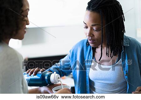 Two female friends, in kitchen, making drink View Large Photo Image Stock Photo - Two female friends, in kitchen, making drink. Fotosearch