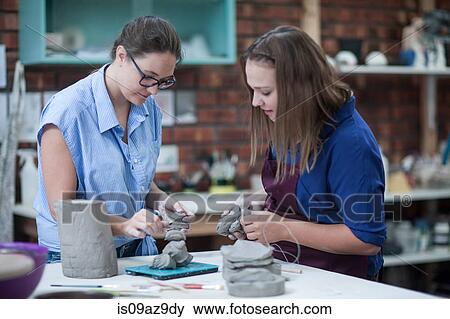 Two female potters shaping clay on workbench in workshop View Large Photo Image Stock Photo - Two female potters shaping clay on workbench in workshop. Fotosearch