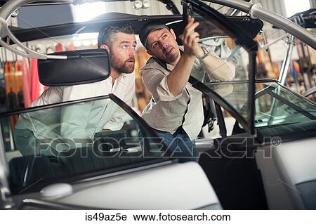 Two men checking motor boat in repair workshop View Large Photo Image Stock Image - Two men checking motor boat in repair workshop. Fotosearch