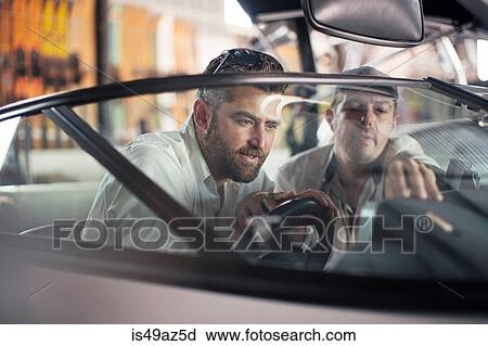 Two men checking steering on boat in repair workshop View Large Photo Image Stock Image - Two men checking steering on boat in repair workshop. Fotosearch
