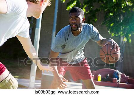 Two men playing basketball on outdoor court View Large Photo Image Stock Image - Two men playing basketball on outdoor court. Fotosearch