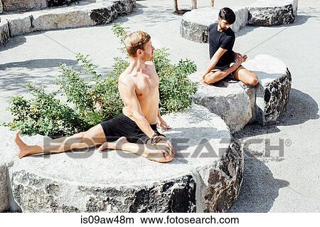 Two men practicing yoga positions together on park stone seats View Large Photo Image Picture - Two men practicing yoga positions together on park stone seats. Fotosearch