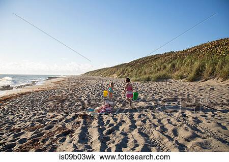 Two sisters playing with toy buckets on beach, Blowing Rocks Preserve, Jupiter Island, Florida, USA View Large Photo Image Stock Image - Two sisters playing with toy buckets on beach, Blowing Rocks Preserve, Jupiter Island, Florida, USA. Fotosearch
