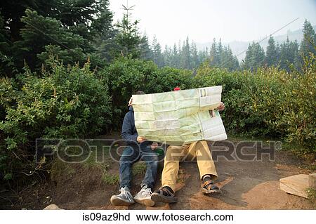 Stock Image - Two young male hikers reading map in forest, Mount Hood National Forest, Oregon, USA. Fotosearch